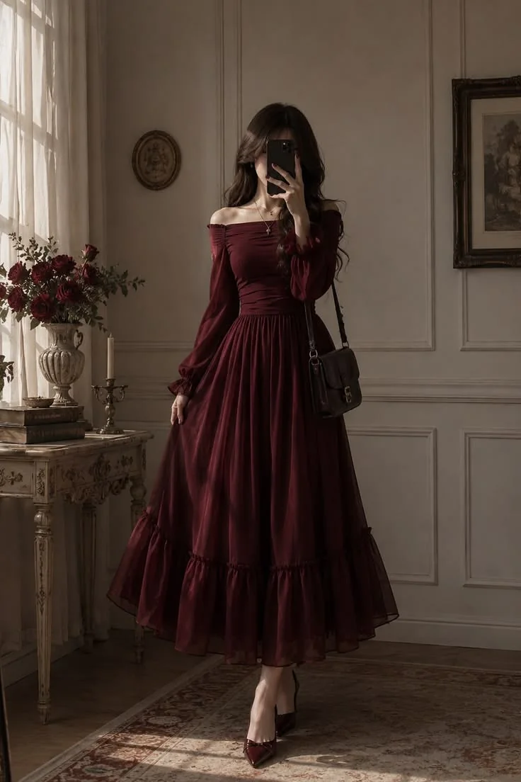 Model in the Bordeaux off-shoulder maxi dress holding a black handbag