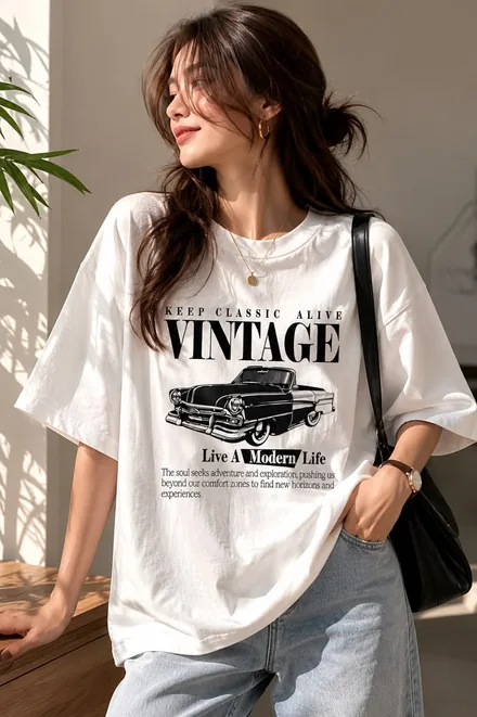 Smiling model wearing an oversized white vintage graphic tee with jeans